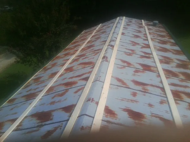 Rusted metal roof panels with new wood purlins before replacement — Storm Damage Roof Repair in Fate by Roofing Brothers