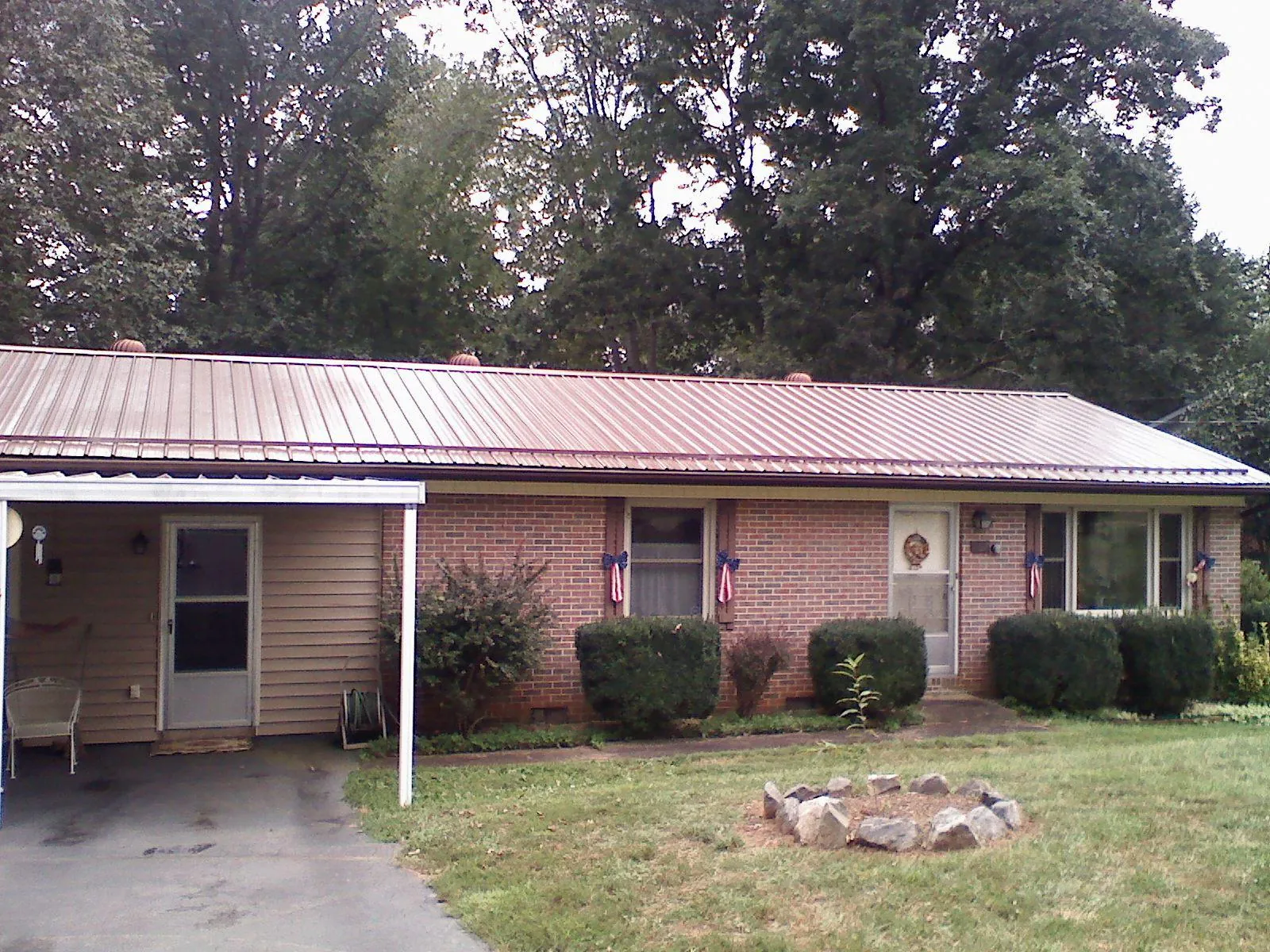 Bronze metal roof and carport on a brick ranch home — Roof Repair work by our crew in Fate