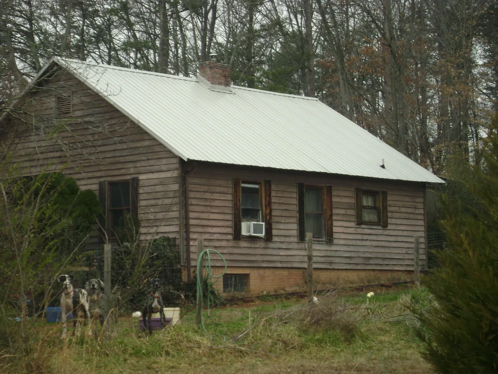 White metal roof on an old wood sided farmhouse, from a Metal Roof Installation job in Fate